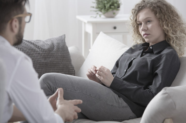woman sitting on couch in therapy